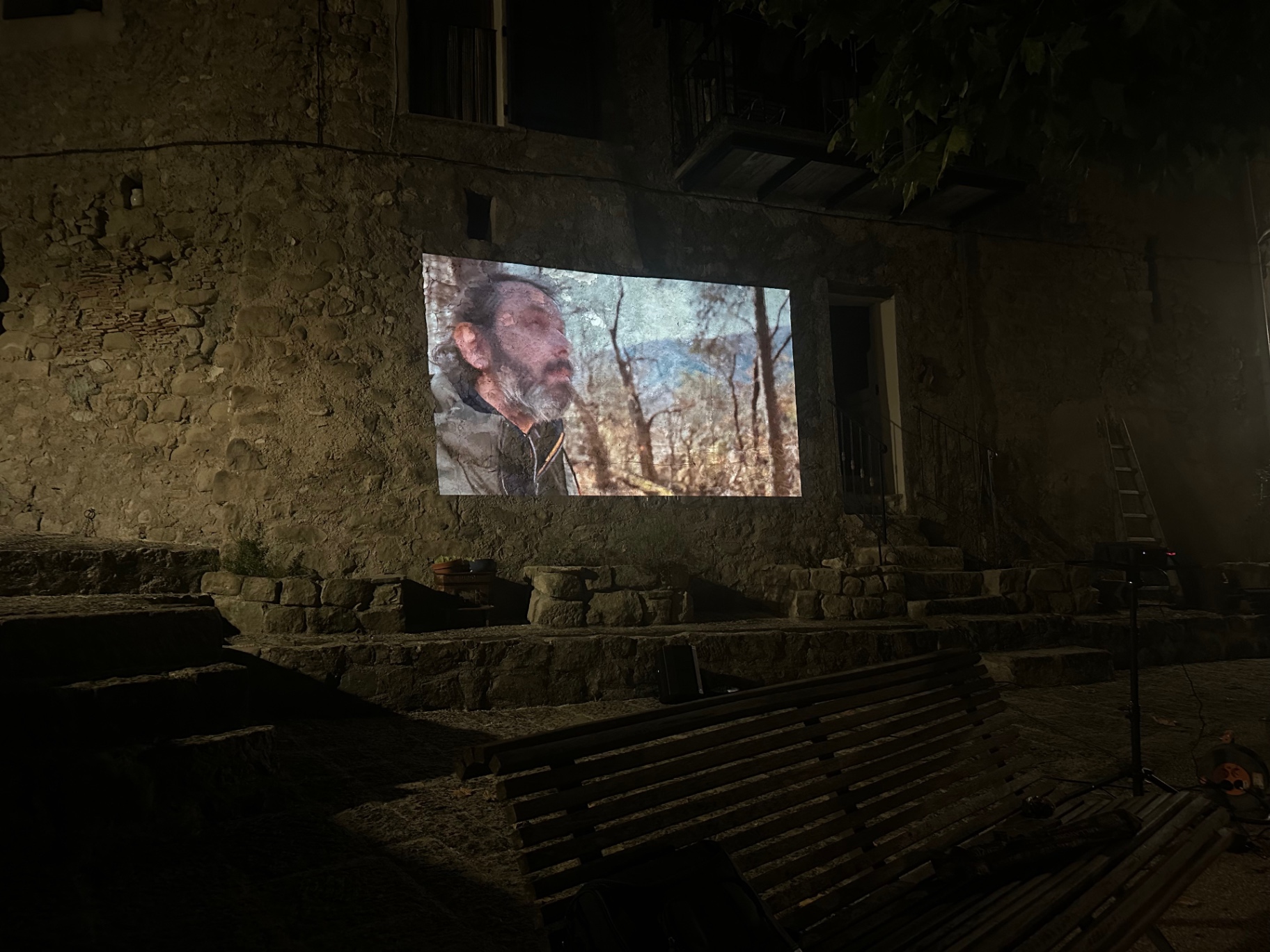 Le colporteur levant les yeux, projeté sur la pierre ancienne.