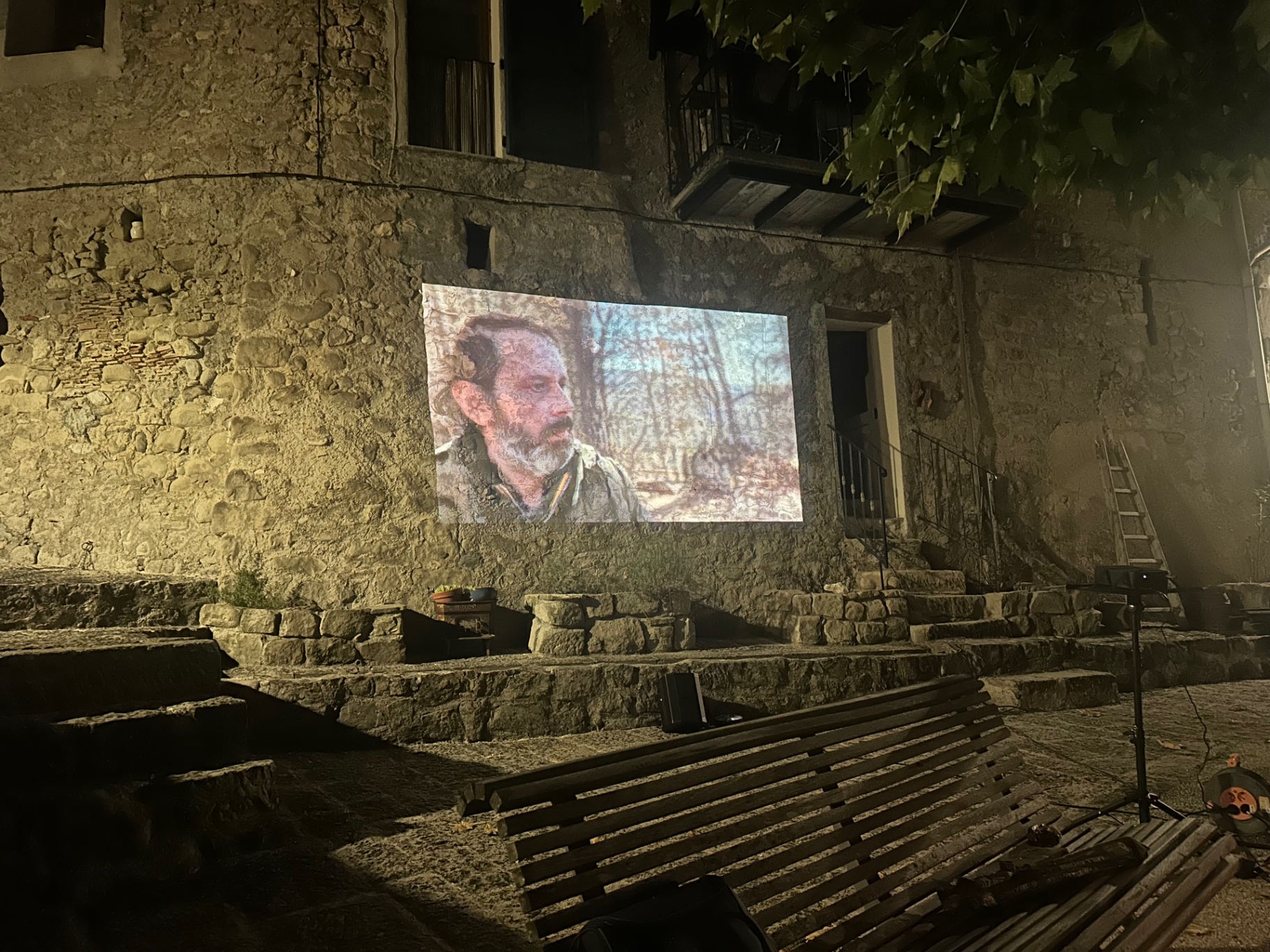 Projection en plein air à Annot : gros plan du colporteur dans la forêt.